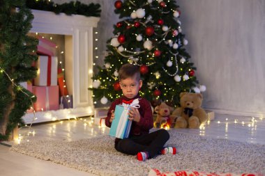 küçük çocuk Noel hediyeleri yeni yıl Noel ağacı Garland ışıkları açar