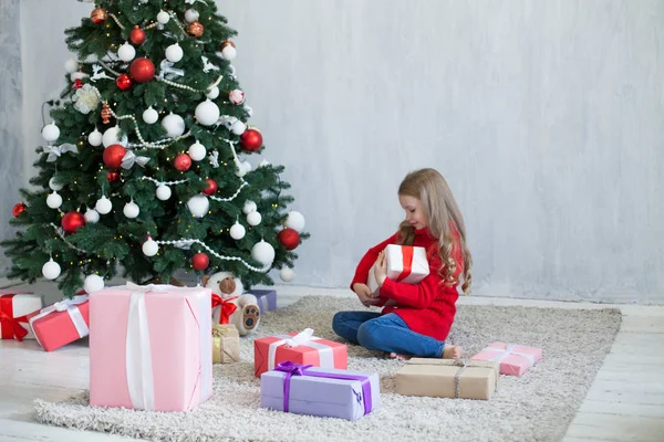 Mała dziewczynka otwiera nowy rok prezenty choinkowe — Zdjęcie stockowe