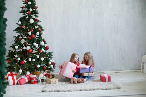 Две девушки открывают рождественские подарки новогодняя елка Гарланд огни — стоковое фото