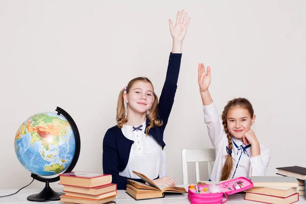 Duas meninas na sala de aula Aprenda livros de aula em seu globo de mesa — Fotografia de Stock