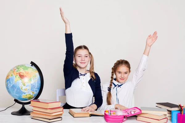 Two girls in the classroom Learn lesson books at her desk globe — Stock Photo, Image