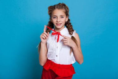 Örgüler ile mavi arka plan üzerinde kırmızı bir kalem ile güzel kız portresi