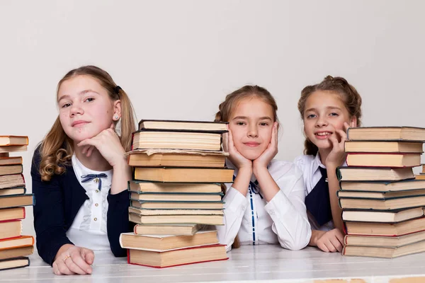 Tři dívky v učebně studuje mnoho knih — Stock fotografie