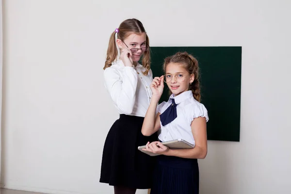 Due ragazze in bicchieri alla lavagna in una lezione di classe — Foto Stock