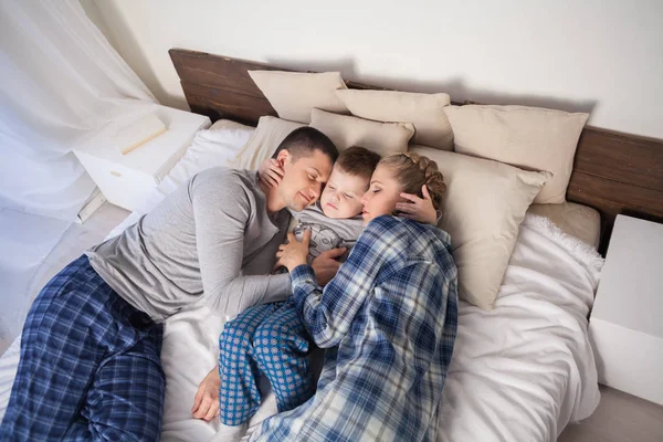 Mamá papá e hijo pequeño en la mañana en el fin de semana de humor dormitorio — Foto de Stock