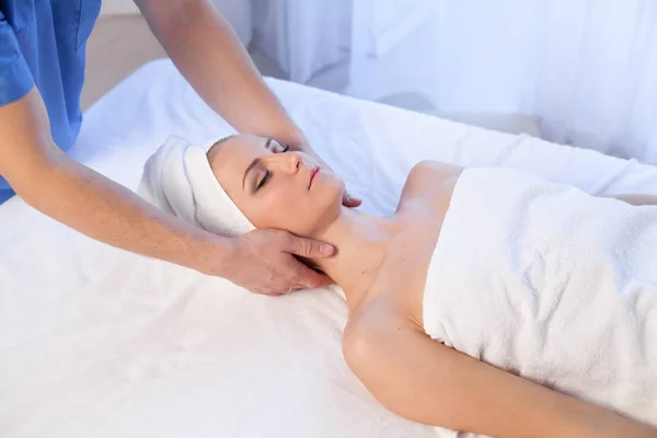 Mooie vrouw maakt therapeutische massage van het gezicht en de hals massage therapeut therapie — Stockfoto