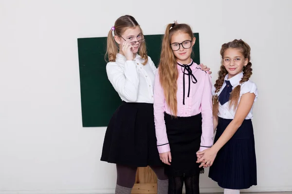 Three girls in glasses at the Blackboard in a class lesson — Stock Photo, Image