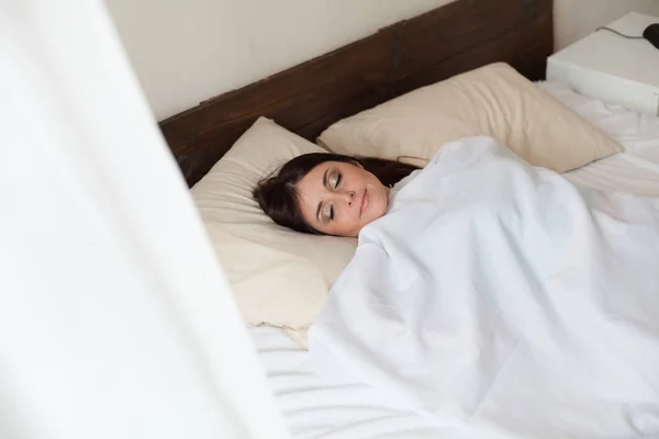Красивая женщина спит одна в спальне на кровати — стоковое фото
