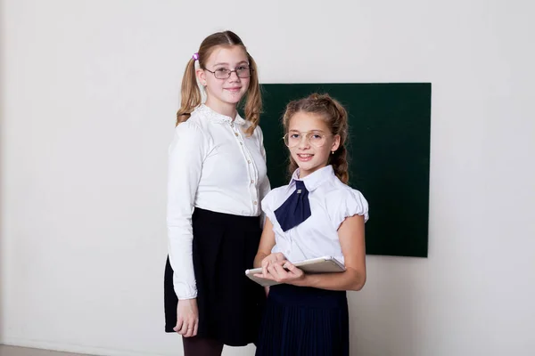 Due ragazze in bicchieri alla lavagna in una lezione di classe — Foto Stock