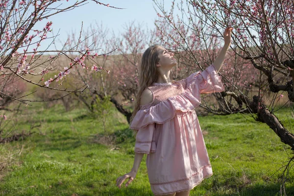 Pembe çiçek bahçesi güzel sarışın kadın — Stok fotoğraf