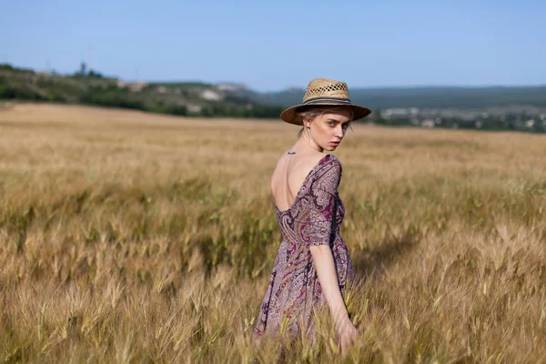 Olgun buğday hasat alanında şapkalı bir kadın çiftçi — Stok fotoğraf