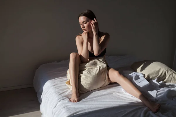 Bella donna in biancheria intima si trova sul letto in camera da letto il sonno del mattino — Foto Stock