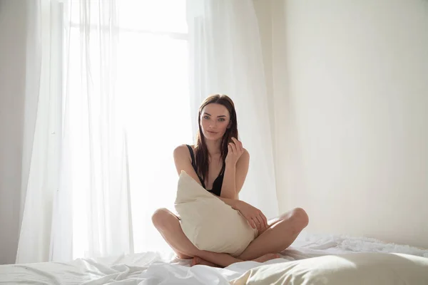 Hermosa mujer en ropa interior se encuentra en la cama en el dormitorio —  Fotos de Stock