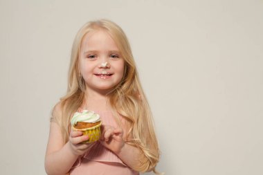 küçük kız elinde tutan bir tatlı kek pasta