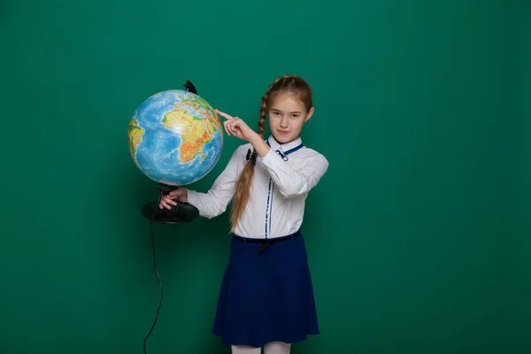 Una ragazza esamina la lezione di geografia del mondo — Foto Stock