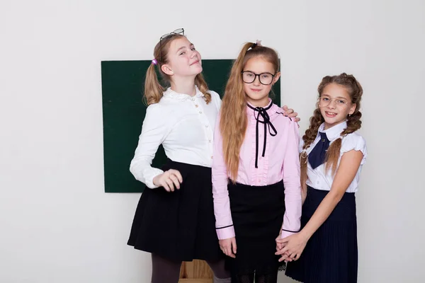 Tre ragazze studentessa in occhiali alla lavagna sulla lezione a scuola — Foto Stock