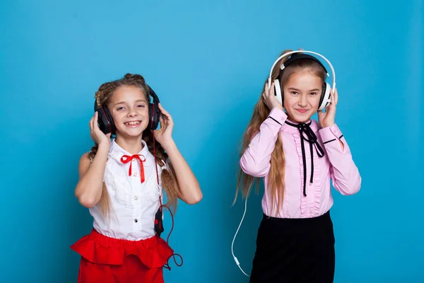 Due ragazze stanno ascoltando musica con cuffie e danza — Foto Stock