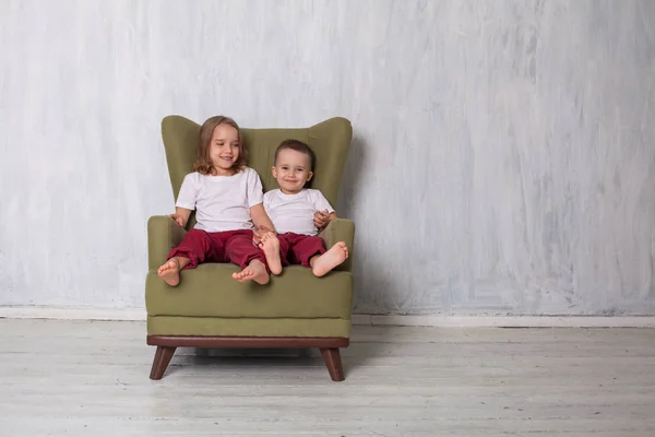 소년과 소녀는 오 빠와 여동생 방에 녹색 소파에 앉아 — 스톡 사진