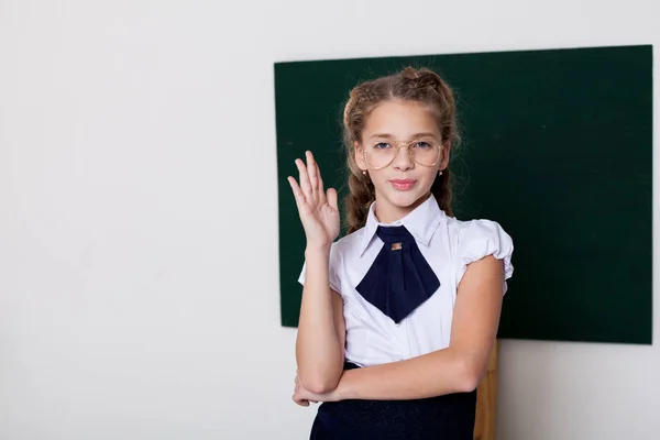 Ragazza scuola ragazza in occhiali alla lavagna sulla lezione a scuola — Foto Stock
