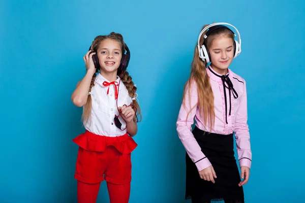Due ragazze stanno ascoltando musica con cuffie e danza — Foto Stock