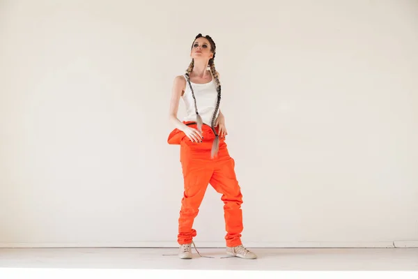 Hermosa mujer de moda con trenzas bailando overoles de trabajo —  Fotos de Stock