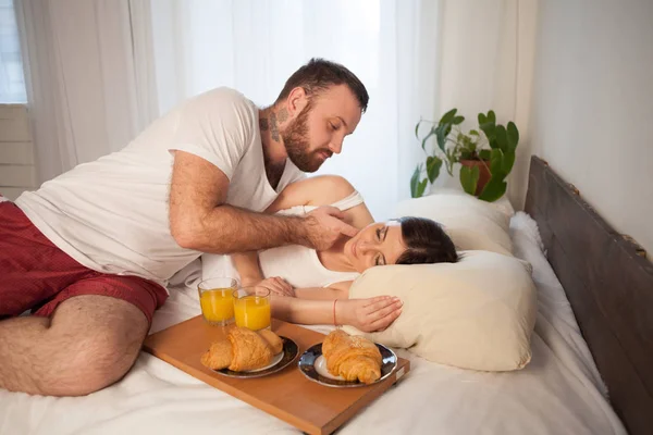 husband and wife in bed in the morning woke up to breakfast in bed