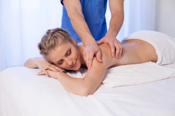 Le médecin fait un massage du dos et des soins du corps fille spa — Photo