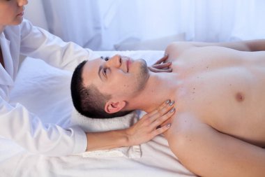 Doktor kozmetolojist yüz masajı yapıyor. Erkekler spa tedavisi görüyor.