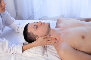 Doktor kozmetolojist yüz masajı yapıyor. Erkekler spa tedavisi görüyor.