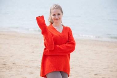 kumsalda, bir Karadeniz kıyısında yürüyüş kazaklı kadın