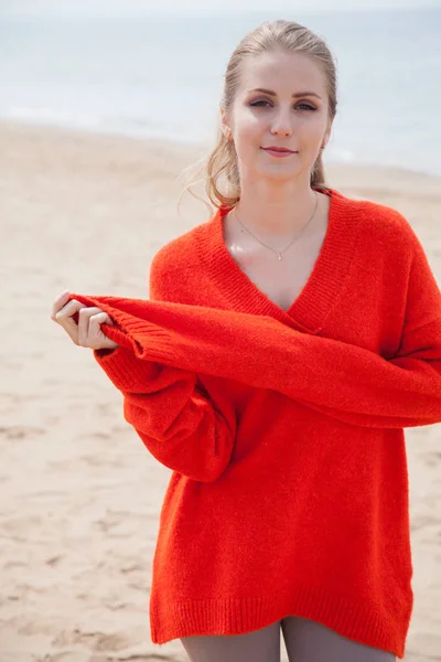 Жінка в светрі, що йде на піщаному пляжі, одне морське узбережжя — стокове фото
