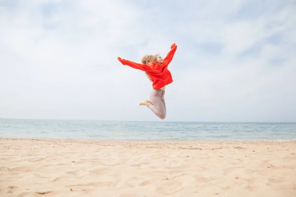 Женщина прыгает на вершину и песчаный пляж Лицензионные Стоковые Изображения