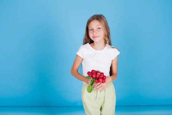 Bambina che tiene un ravanello rosso verdure alimentari sane — Foto Stock