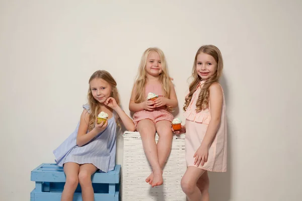 Три маленькі дівчата їдять солодкий торт з вершковим кексом — стокове фото