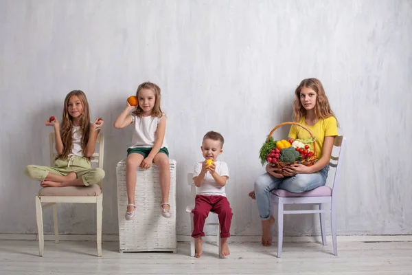 I bambini si siedono con verdure fresche mangiare sano frutta — Foto Stock