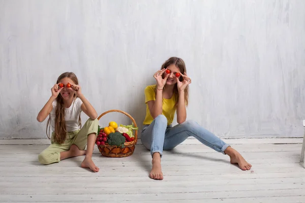 Niños se sientan con verduras frescas comiendo frutas saludables — Foto de Stock