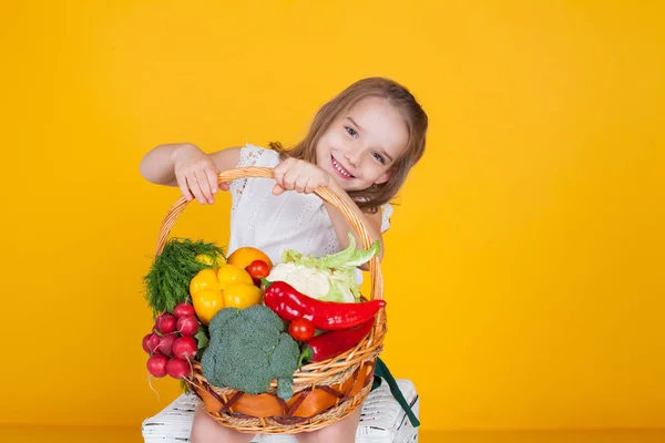 Beautiful girl holding a basket of ripe vegetables healthy food — Stock Photo, Image
