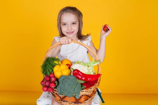 Beautiful girl holding a basket of ripe vegetables healthy food — Stock Photo, Image