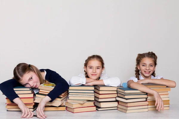 Drie meisjes op school in de klas voor boeken van kennis — Stockfoto