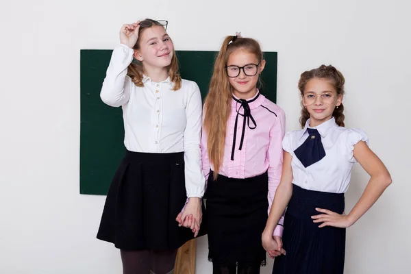 Tre ragazze in bicchieri alla lavagna in una lezione di classe — Foto Stock