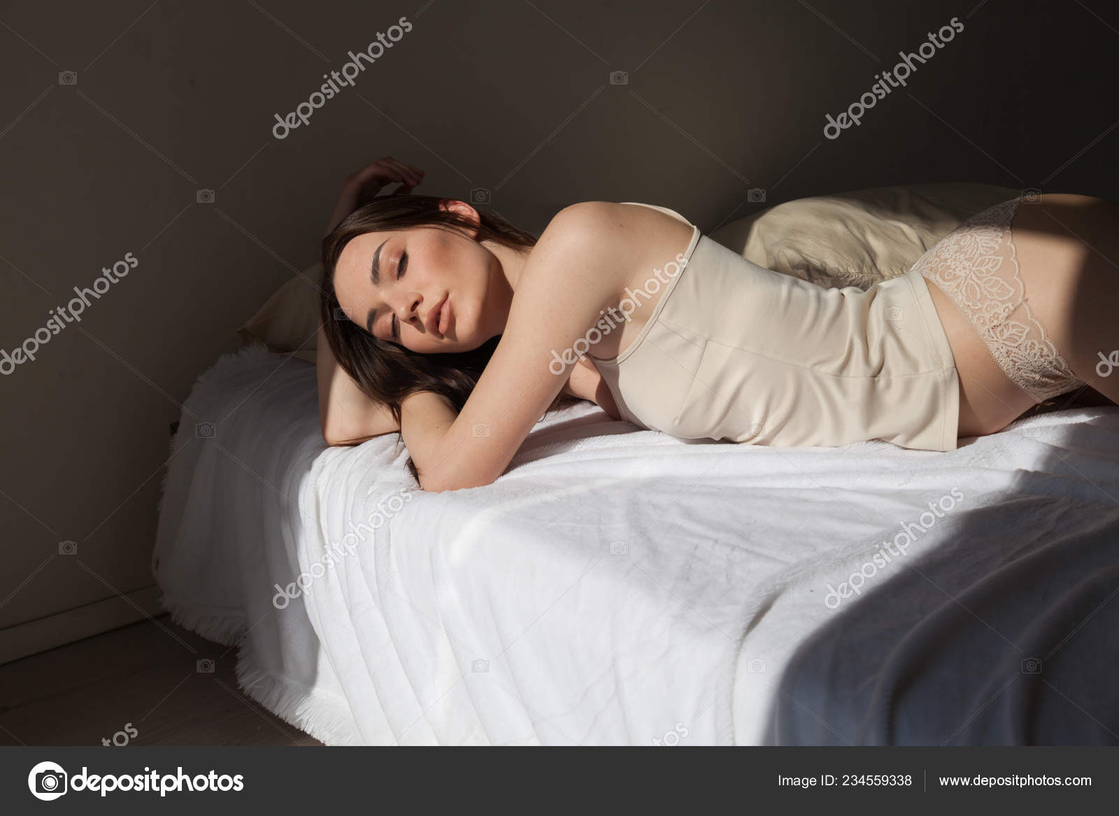 Beautiful woman in lingerie lying on a bed in the bedroom Stock Photo by  ©dsimakov-foto.mail.ru 234559338