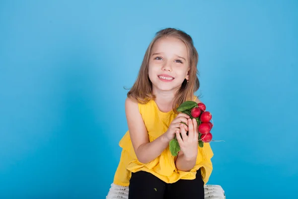 Piccola bella ragazza che tiene un ravanello fresco cibo sano — Foto Stock