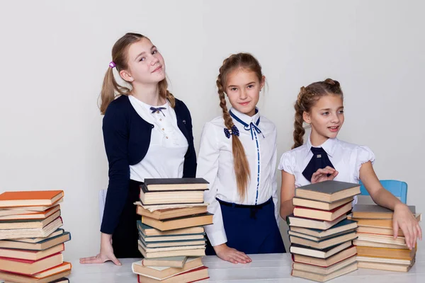 Duas meninas alunas sentar com livros em sua mesa sobre a lição na escola — Fotografia de Stock