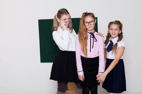 Τρία κορίτσια μαθήτρια στέκεται στο μαυροπίνακα με μάθημα — Φωτογραφία Αρχείου