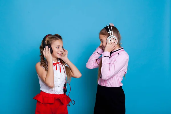Due ragazze con le cuffie che ascoltano musica e ballano — Foto Stock