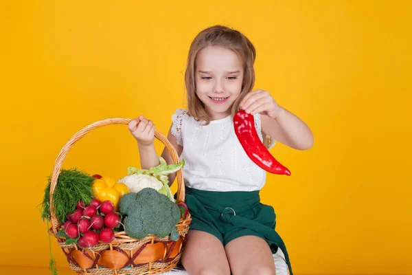 Small beautiful girl holding a basket of fresh fruit and vegetables healthy food — Stock Photo, Image