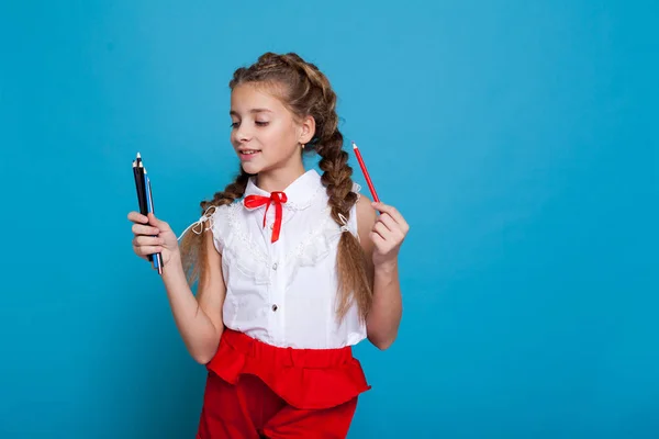 Ragazza trecce tiene pastelli classe della scuola bello — Foto Stock