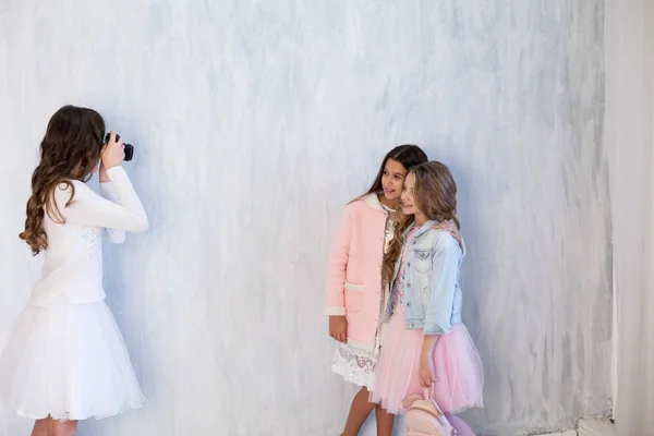Üç moda kız okul arkadaşı ile bir fotoğraf makinesi — Stok fotoğraf