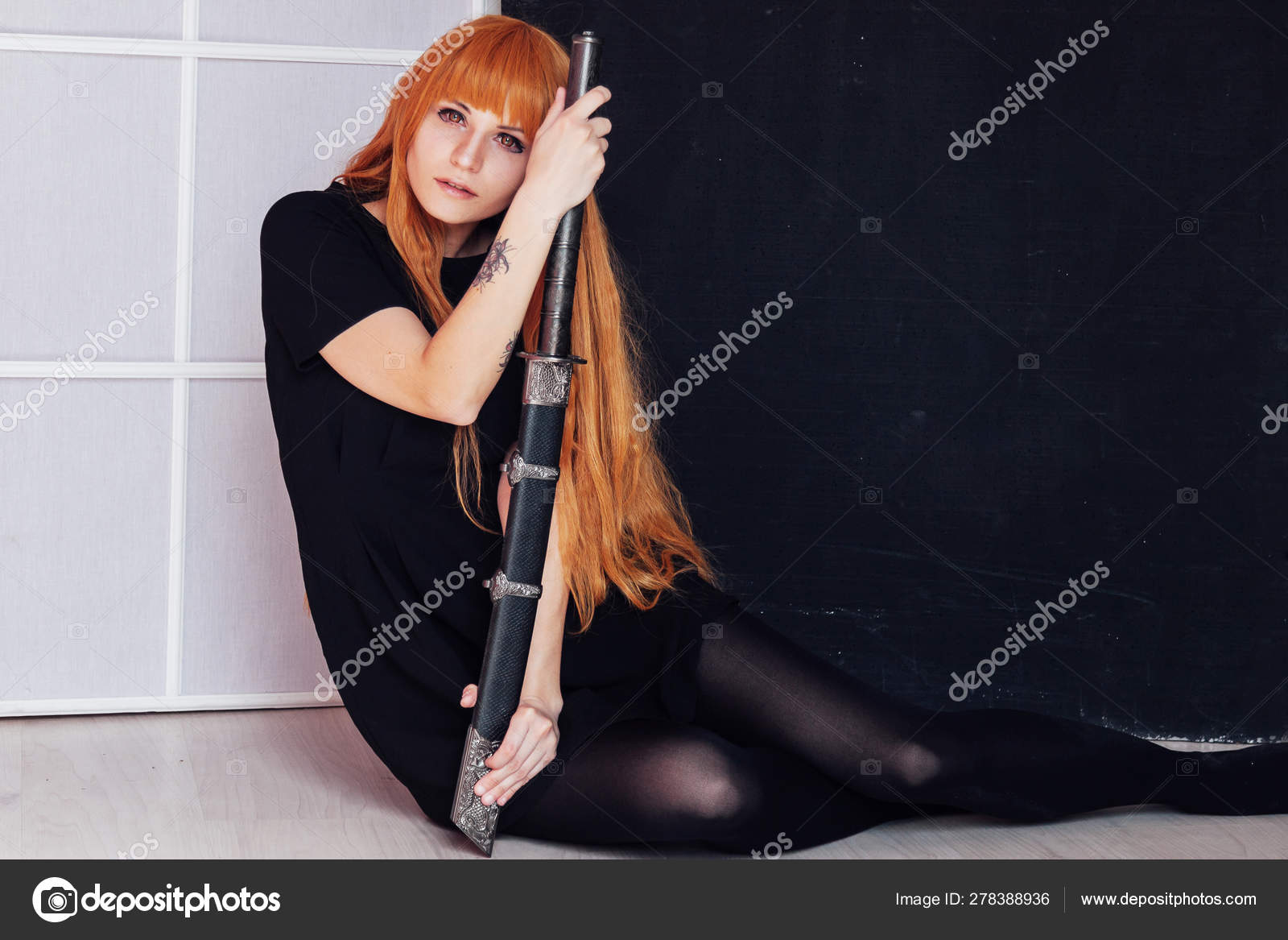 Young Woman In Japanese Anime Cosplay Holding Samurai Sword