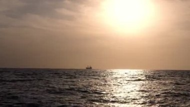 Deniz giden gemiler, tankerler siluetleri ile Altın günbatımı